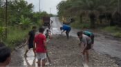 Foto Menanti Inpres Jalan Daerah, warga sedang menimbun lubang jalan di ruas Trans Kalimantan Desa Hajak Barito Utara.