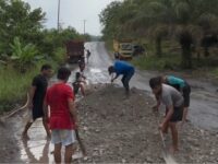 Foto Menanti Inpres Jalan Daerah, warga sedang menimbun lubang jalan di ruas Trans Kalimantan Desa Hajak Barito Utara.
