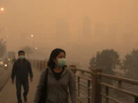 Warga menggunakan masker saat beraktivitas di tengah kabut asap