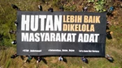 Masyarakat adat Dayak Taboyan membentangkan spanduk untuk menjaga hutan Desa Tongka