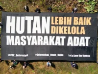 Masyarakat adat Dayak Taboyan membentangkan spanduk untuk menjaga hutan Desa Tongka
